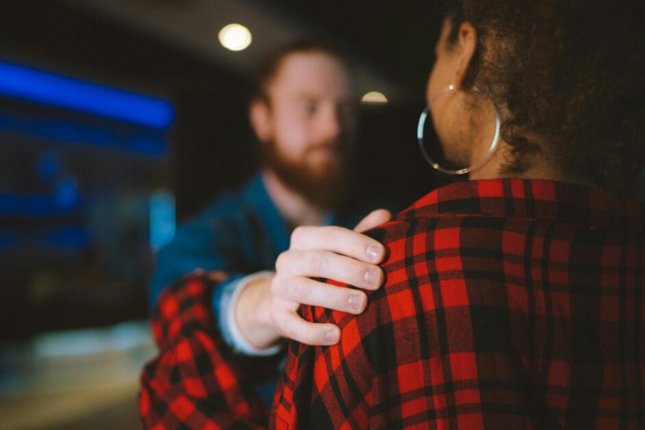 A person offering support with a comforting hand on the shoulder, emphasizing the importance of empathy and understanding to boost emotional intelligence