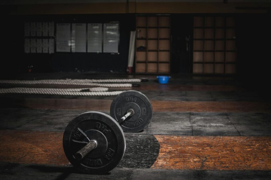 Productivity hacks: A barbell and weights in a dark gym.  