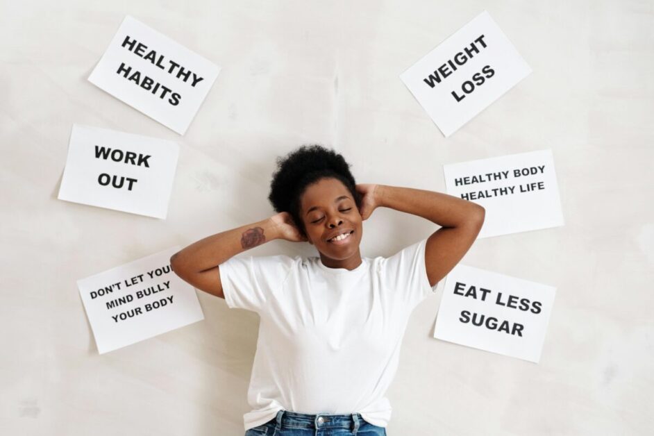 Woman in White Crew Neck Shirt Standing Beside a Wall with Posted Papers on Healthy habits
