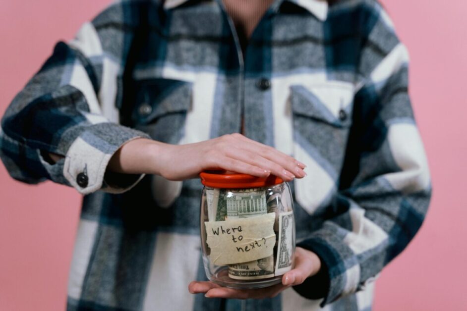 A person's hands carefully holding a jar filled with US dollar bills, reflecting the challenges and uncertainty of personal money management.
This image visually conveys the central theme of 